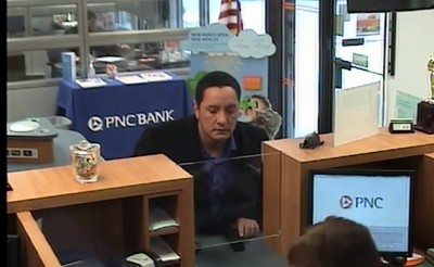 The suspect in a Feb. 5 bank robbery pulls a gun on a bank teller in Toms River. (Photo: TRPD)