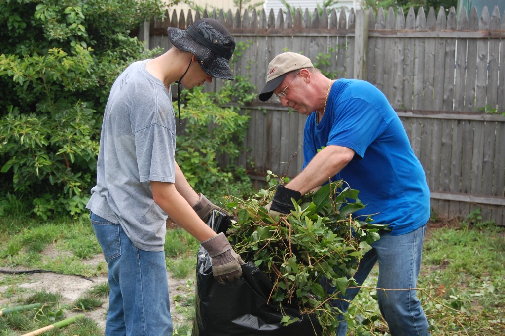 Volunteers with Northern Ocean Habitat for Humanity help spruce up a yard in Brick. (Photo: Daniel Nee)