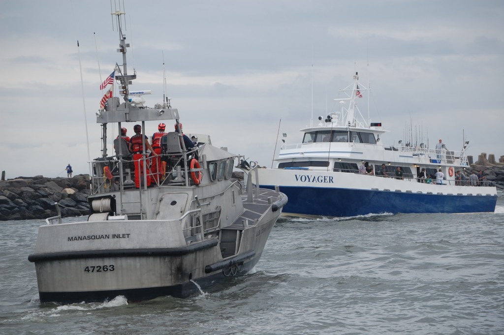 A U.S. Coast Guard crew keeps watch over a party boat entering Manasquan Inlet, Sept. 30, 2015. (Photo: Daniel Nee)