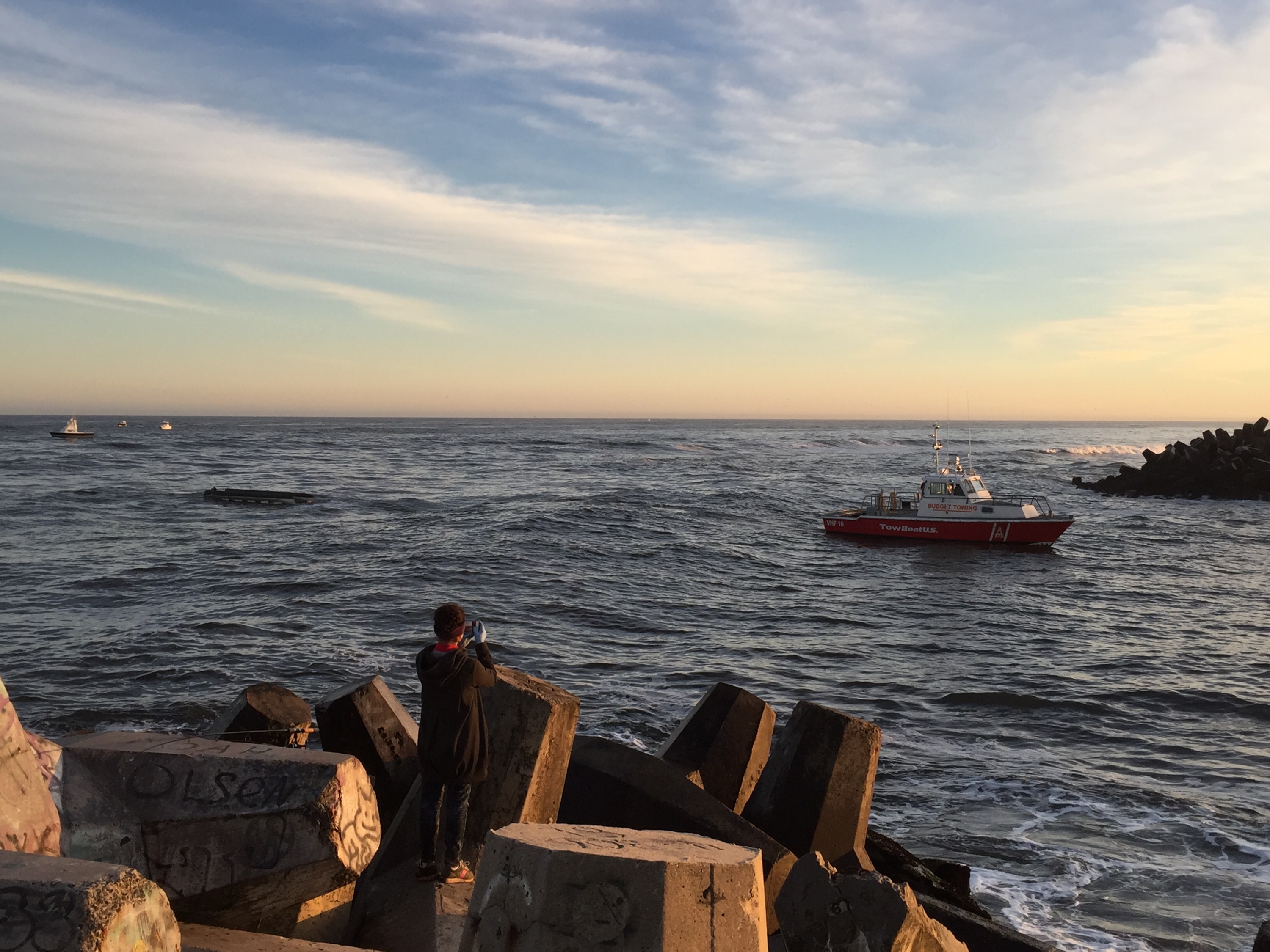 A pontoon boat that capsized off Manasquan Inlet is towed in. (Photo: Daniel Nee)