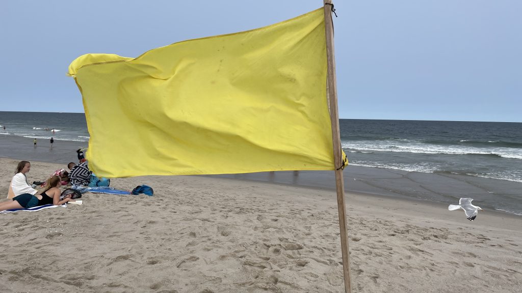 A single-yellow flag flies at Brick Beach III, Aug. 2023. (Photo: Shorebeat)